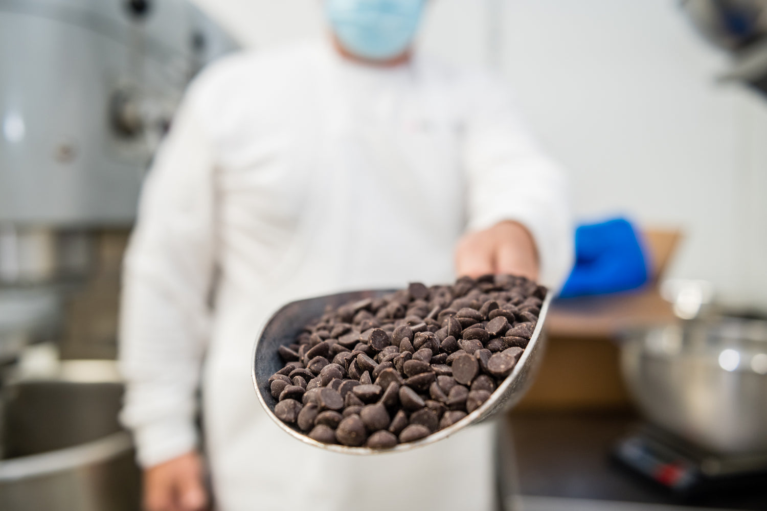 man holding scoop of chocolate chips