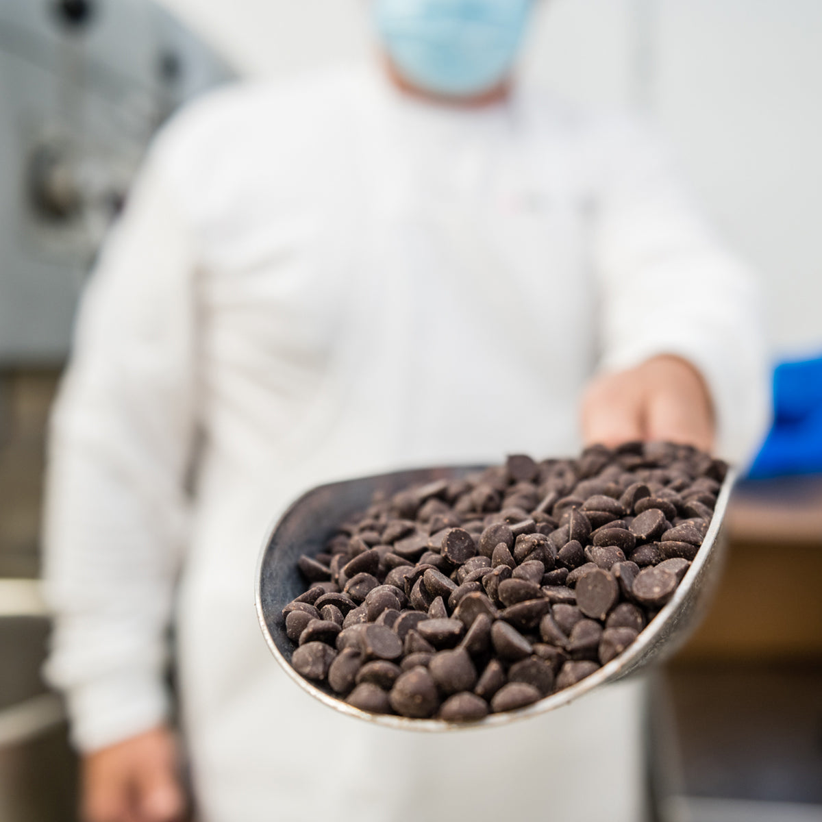 man holding scoop of chocolate chips