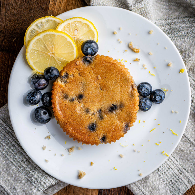 Nani Sweets Lemon Blueberry Amazing Cake with lemon slices and blueberries on a white plate